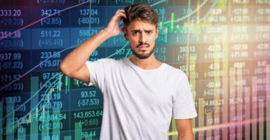 confused man in front stock market charts