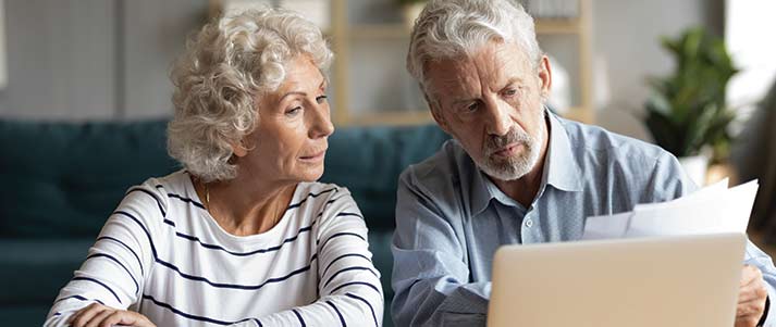 elderly couple looking at laptop