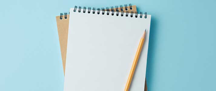 notebooks and pencil against blue background