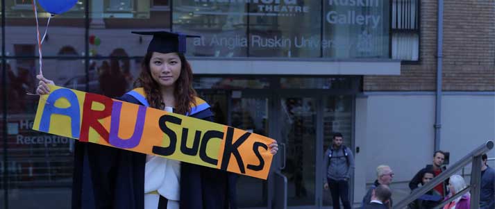 Pok Wong holding 'ARU sucks' sign