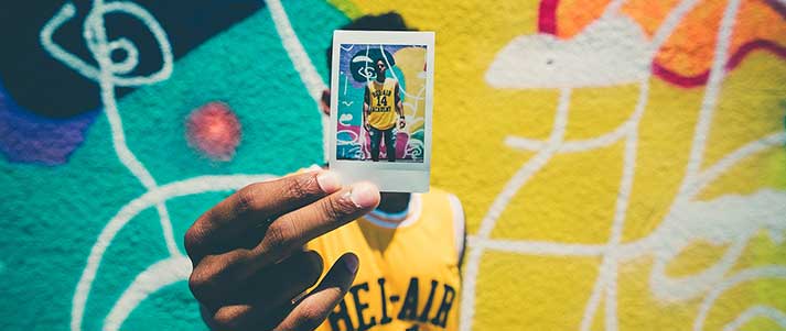 Man holding Polaroid self-portrait