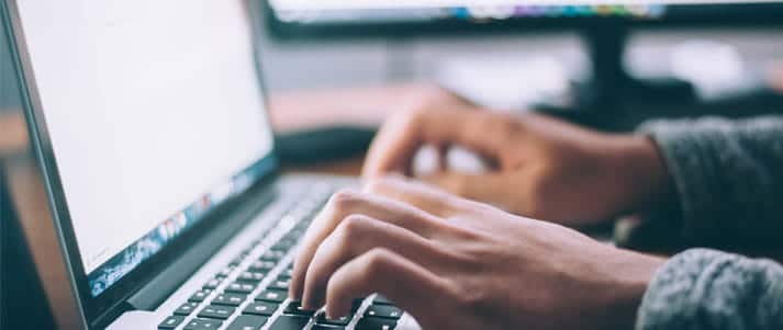 hands typing on a laptop