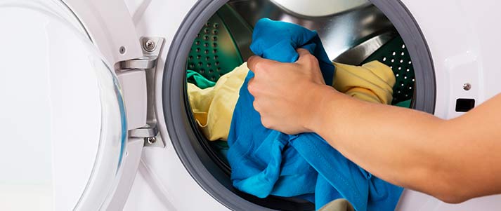 person loading washing into machine