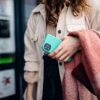 woman holding blue phone case on walk