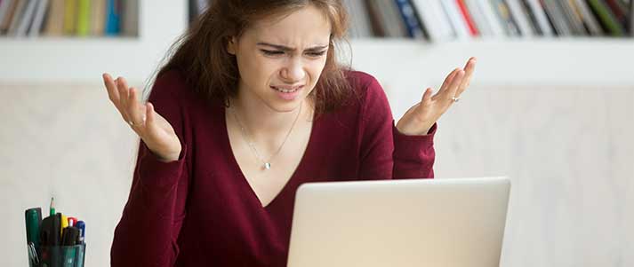 Woman shrugging at laptop