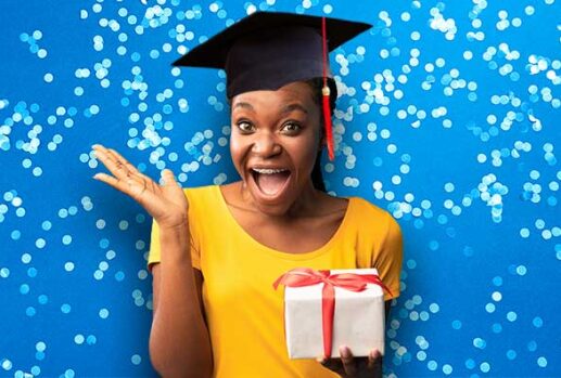 Woman with graduation cap holding present