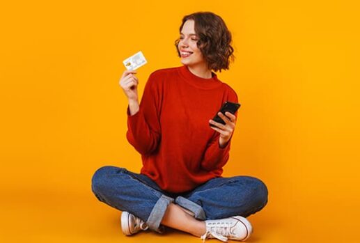 woman holding card and mobile