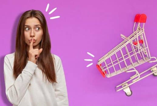 woman holding finger in front of her lips and shopping cart